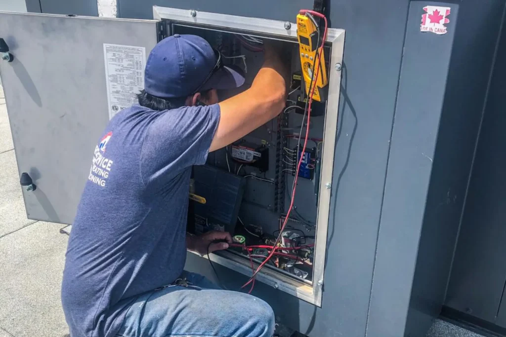 Technician working on commercial electrical equipment.